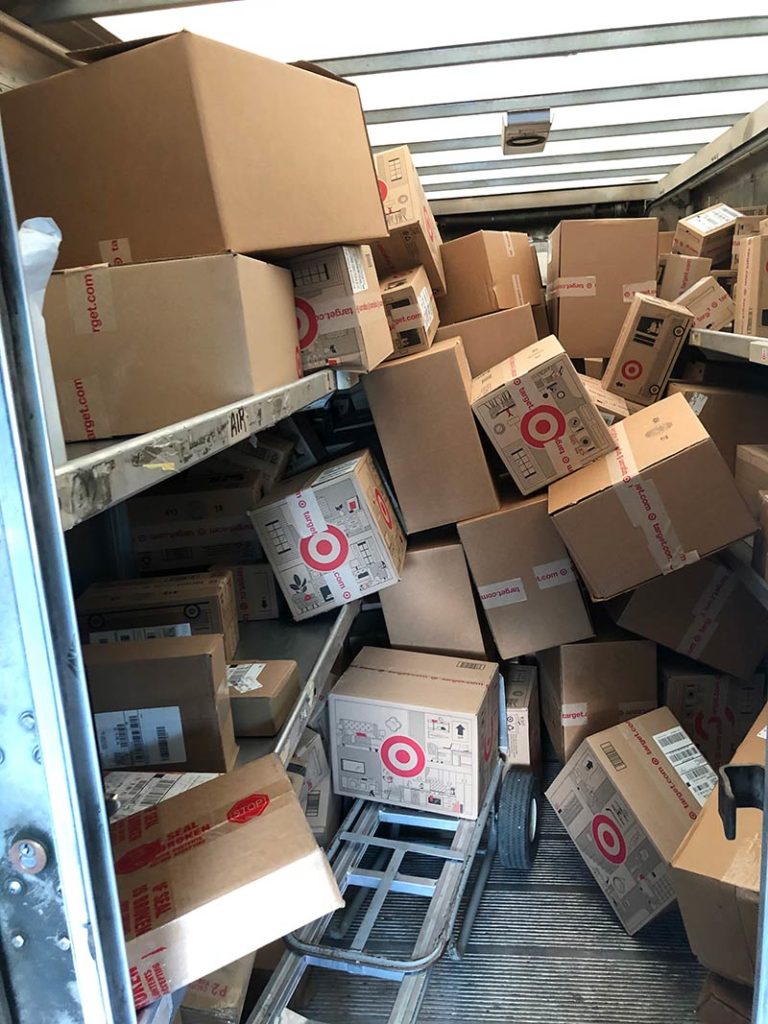 The back of a UPS truck with boxes jammed in.